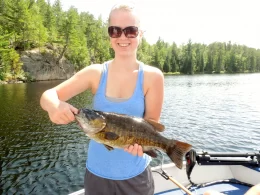 Girl Holidng Bass Caught In Fishing Boat